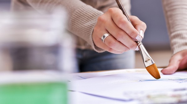 Female artist painting with brush on paper