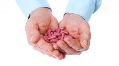 Man's hands cupping herbal supplement pills