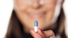 woman holding vitamin capsule