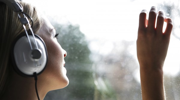 Portrait of young woman listening to headphones at home 