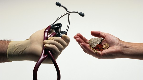 Hands Holding a Stethoscope and Herbs