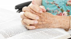 Praying Senior Hands on Bible